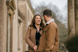 Stourhead Wedding Photographer32 A Stourhead wedding photographer captures a tender moment as a man and woman lock eyes in front of a picturesque building.