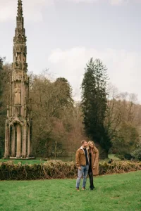 Stourhead Wedding Photographer36 A couple, captured by a Stourhead wedding photographer, standing in front of a tower in a park.