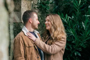 Stourhead Wedding Photographer9 A couple is embracing in front of a stone wall at a Stourhead wedding, captured by the talented Stourhead Wedding Photographer.