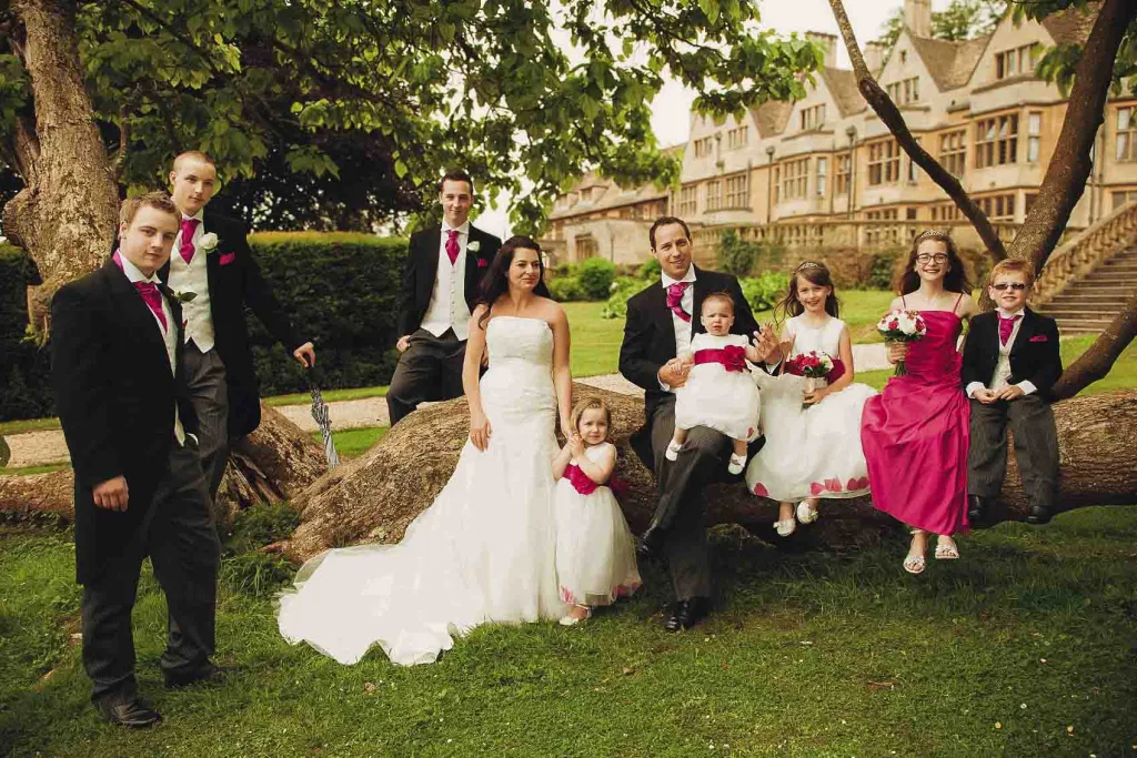 A wedding party posing in front of a tree at Coombe lodge Wedding Venue