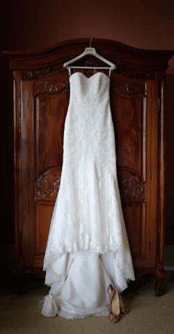 www.thefxworks.co.uk Orchardleigh House Photos show a wedding dress gracefully hanging on a dresser in a room.