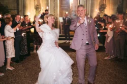 A bride and groom at Orchardleigh House, joyfully holding sparklers in their hands.