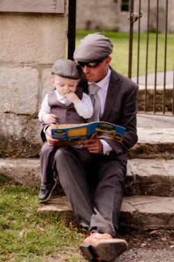a man sitting on a step holding a small child.