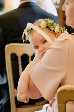A woman holds a baby during a Orchardleigh House wedding ceremony.