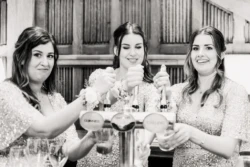 Bridesmaids at Orchardleigh House pouring drinks at a bar.