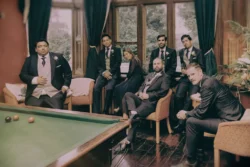 A group of men posing in front of a pool table at Orchardleigh House.