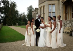 www.thefxworks.co.uk A groom and his bridesmaids dressed in elegant attire posing for a photo outdoors at Orchardleigh House, a stately venue.