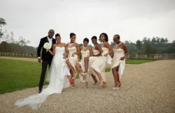 www.thefxworks.co.uk A wedding party posing outdoors at Orchardleigh House, featuring a groom in a black suit and a bride in a white dress accompanied by bridesmaids in cream dresses.