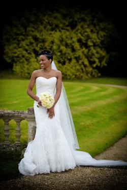 www.thefxworks.co.uk A bride holding a bouquet smiles outdoors with Orchardleigh House's greenery in the background.