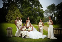 www.thefxworks.co.uk A bride and her bridesmaids posing in elegant white dresses, holding bouquets in an Orchardleigh House garden setting.