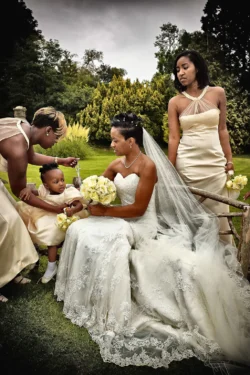 www.thefxworks.co.uk A bride seated outdoors at Orchardleigh House with attendants and a young child in formal wedding attire.