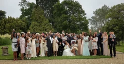Group of wedding guests and newlyweds posing together outdoors at Orchardleigh House.