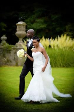 www.thefxworks.co.uk A couple in wedding attire posing in the Orchardleigh House garden, with the bride holding a bouquet and the groom looking into the distance.