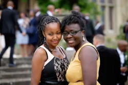 www.thefxworks.co.uk Two smiling women dressed in formal attire at an Orchardleigh House Weddings outdoor event.