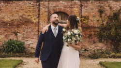 Wedding photography of a bride and groom in Bath, standing in front of a beautiful brick wall.