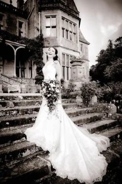 www.thefxworks.co.uk A bride is posing on the steps of Farleigh House.