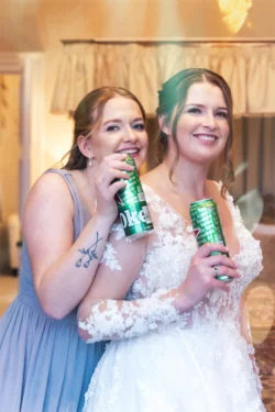 Two bridesmaids holding cans of beer at Orchardleigh wedding.