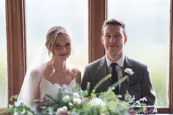 Orchardleigh Wedding Photographer captures a bride and groom posing in front of a window.
