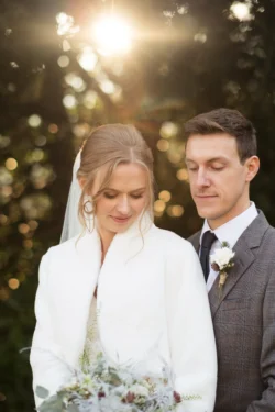 An Orchardleigh wedding photographer captures a beautiful moment of a bride and groom posing in front of the sun.