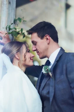 An Orchardleigh Wedding Photographer captures the intimate embrace of a bride and groom in front of a window.