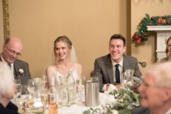 A group of people at Orchardleigh House sitting at a table and laughing.
