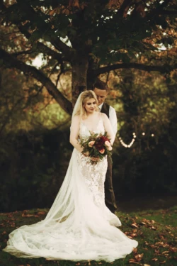 A bride and groom posing in front of a tree. Priston Mill Wedding Photographer