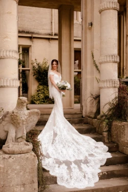 A bride standing on the steps of a mansion.
