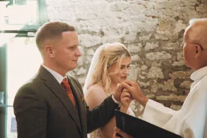 A bride and groom exchange rings during their wedding ceremony.Priston Mill Wedding Photographer