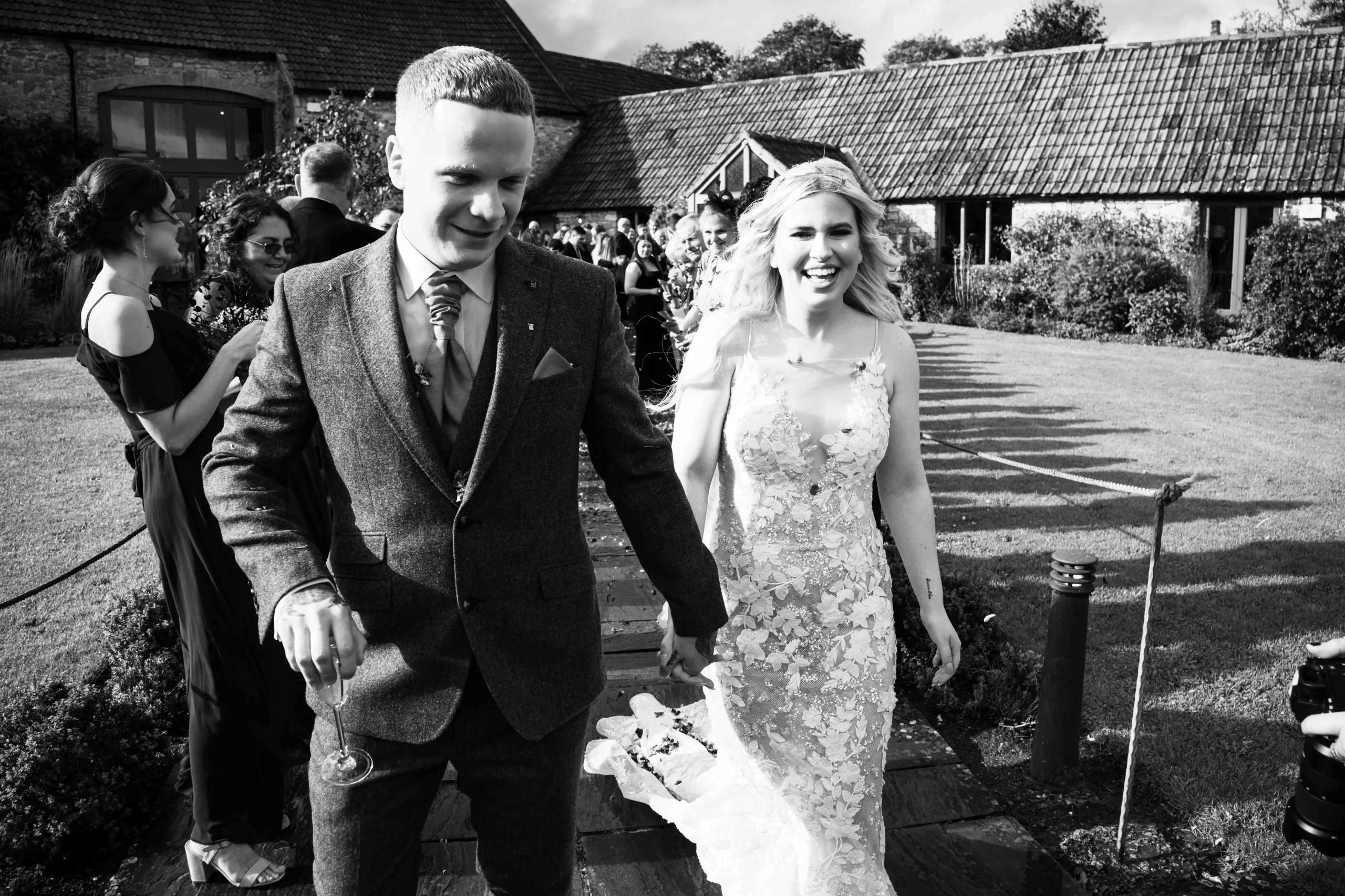 Black and white photo of a bride and groom walking down the aisle.Priston Mill Wedding Photographer