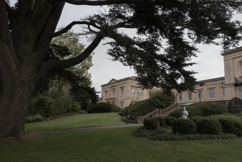A large mansion with a large tree in front of it. Wedding Photographer Bath Spa Hotel