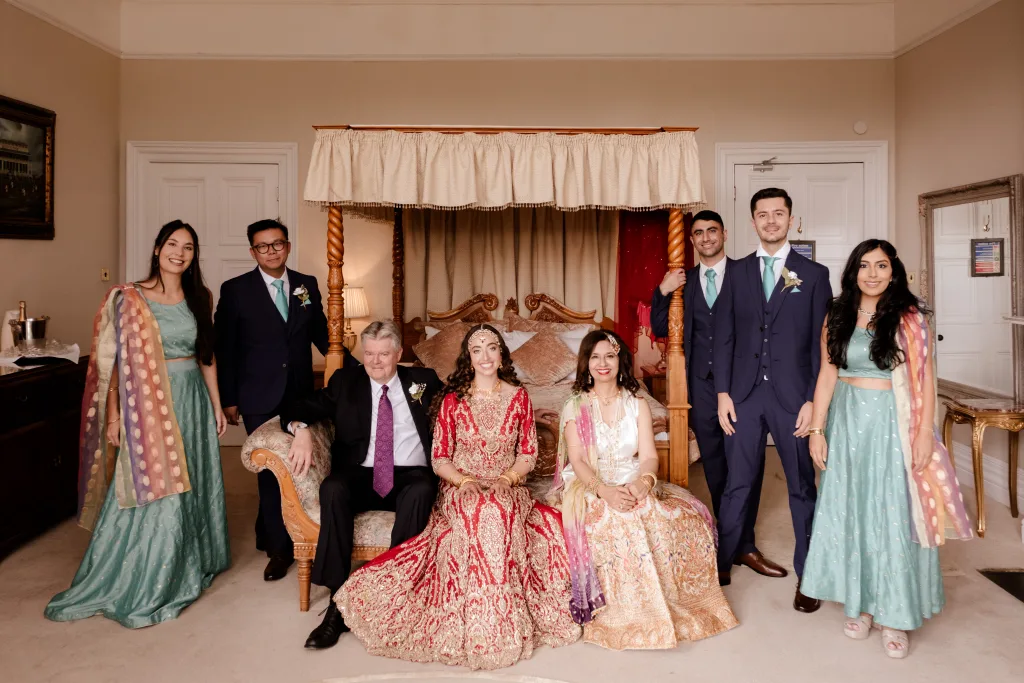 A group of people posing for a photo in a room. Orchardleigh Weddings