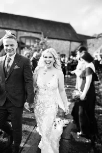 Black and white photo of bride and groom walking down the aisle. Priston Mill Wedding Photographer