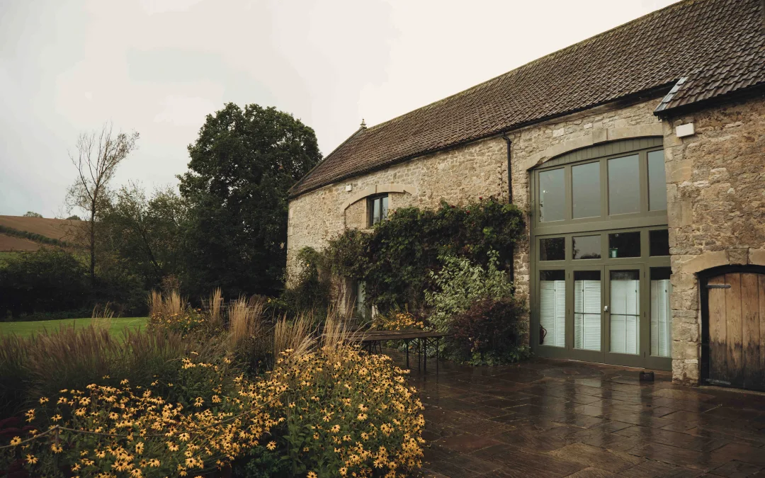 A stone building with a patio and flowers.Priston Mill Wedding Photographer