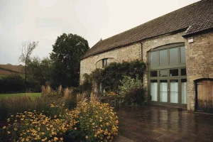 A stone building with a patio and flowers.Priston Mill Wedding Photographer