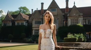 A beautiful bride in a white wedding dress posing in front of a mansion. Longhouse Wedding Photographer
